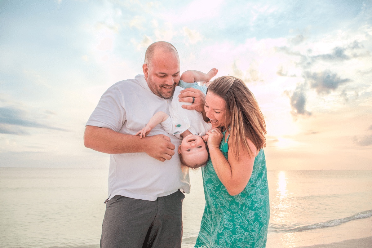 Lido beach photographer and Indian rocks beach photographer portrait at sunset of family of 3 in front of the Gulf of Mexico