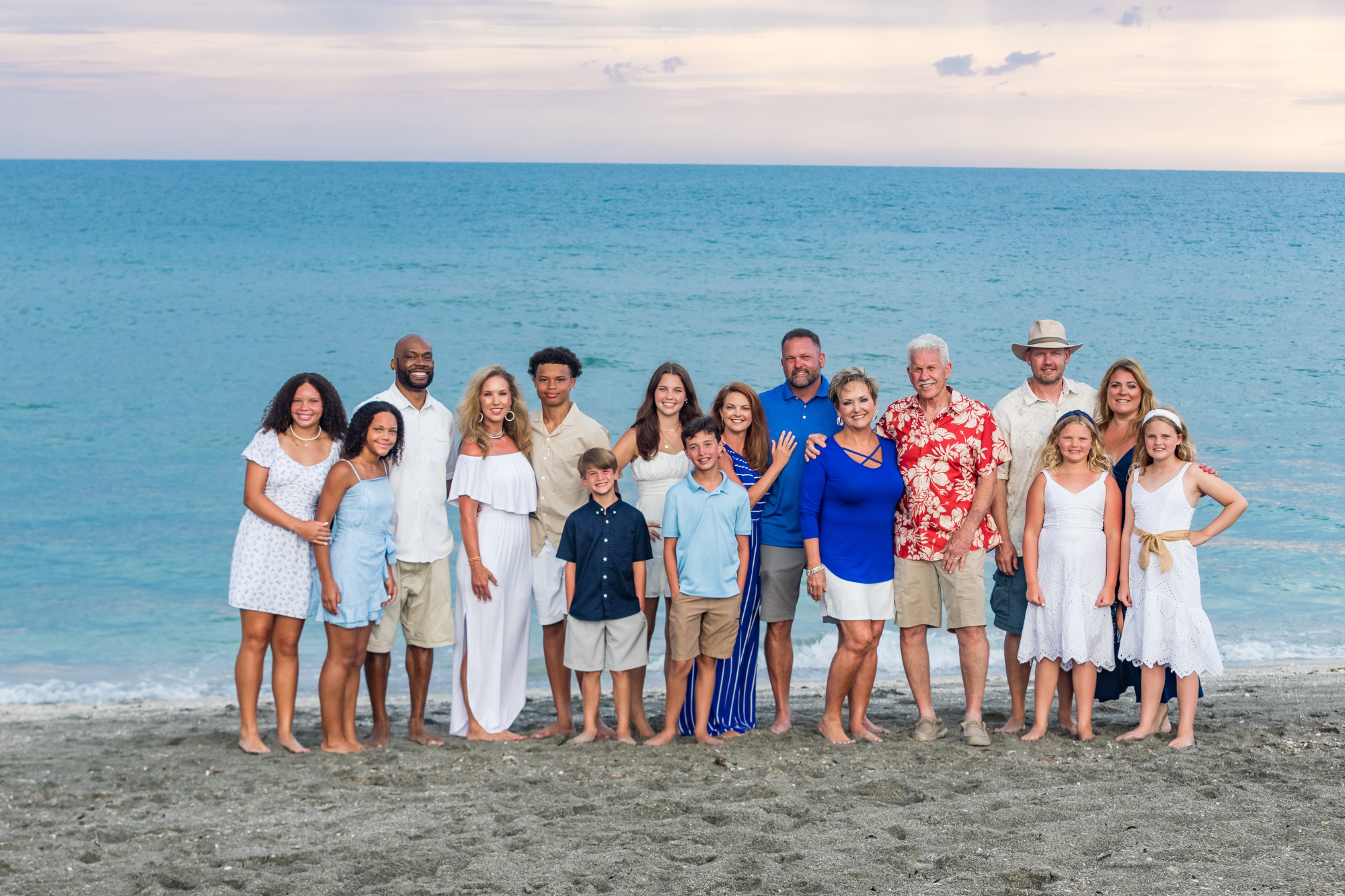 siesta key photographer image of a large extended family posed in front of siesta key beach with grandparents, children and grand children at sunset